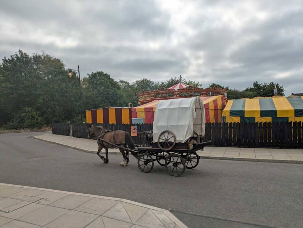 A horse and cart head past the fairground at the Black Country Living Museum in Dudley, West Midlands.