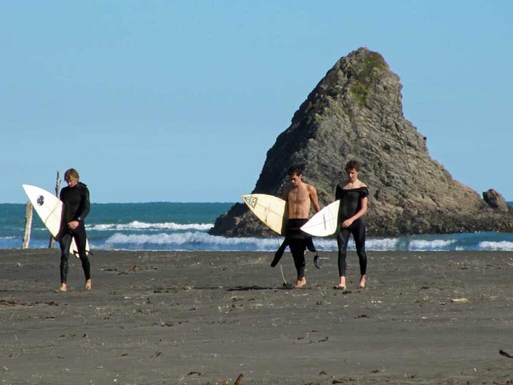 Surfers at Karekare Beach, Auckland.