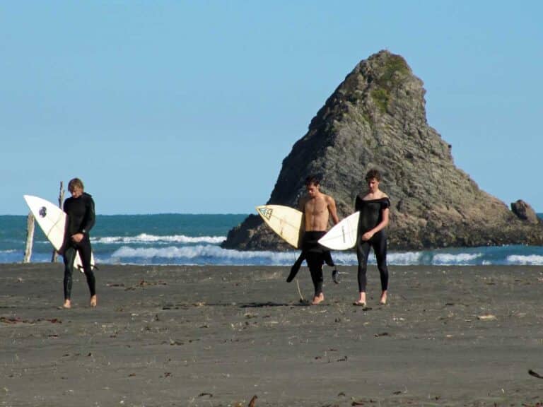 Surfers at Karekare Beach, Auckland.