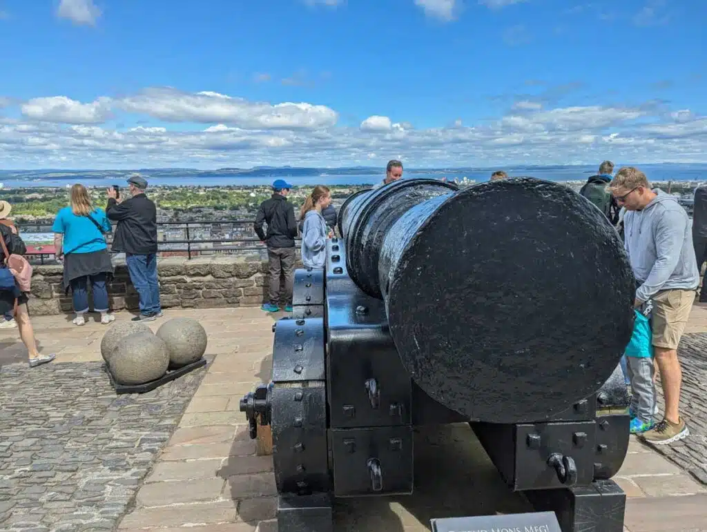 Tourists inspecting Mons Meg at Edinburgh Castle, Scotland.
