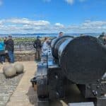 Tourists inspecting Mons Meg at Edinburgh Castle, Scotland.