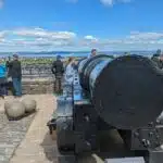 Tourists inspecting Mons Meg at Edinburgh Castle, Scotland.