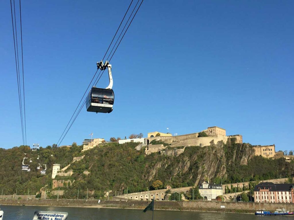 The cable car crosses the Rhine in front of the Ehrenbreitstein Fortress in Koblenz.